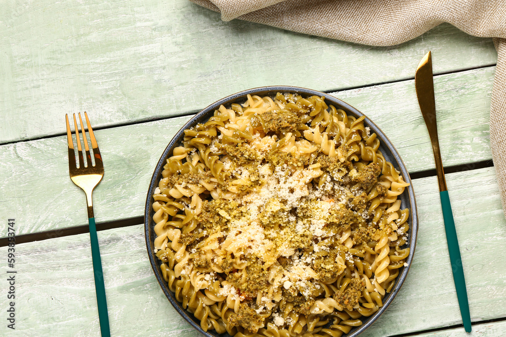 Plate of tasty Italian pasta with Parmesan cheese on light wooden background