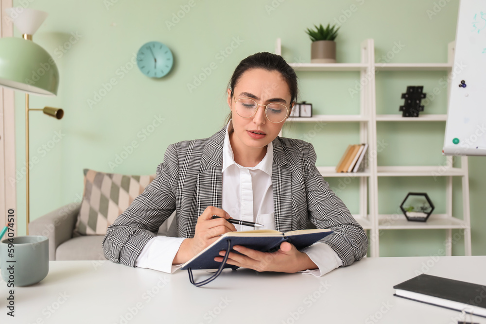 Female tutor with notebook giving online lesson at home