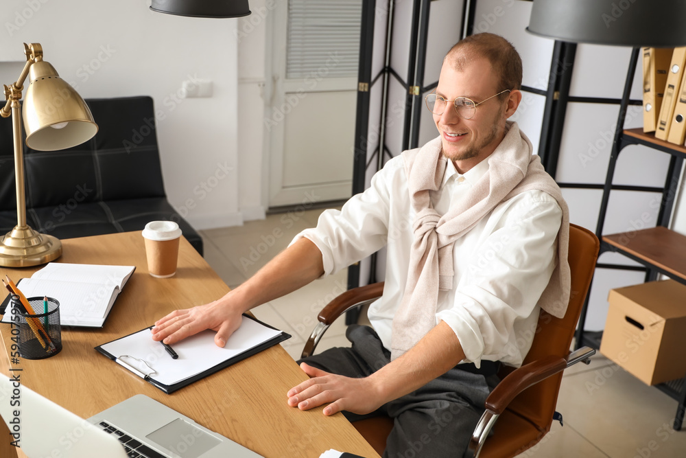 Male tutor with clipboard giving online lesson at home