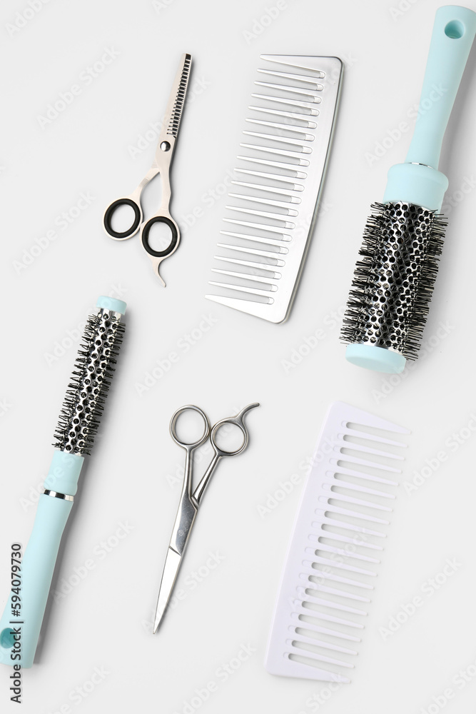 Hair brushes with scissors on light background