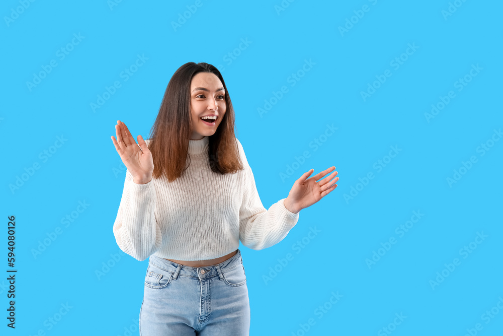 Beautiful happy young woman meeting someone on light blue background