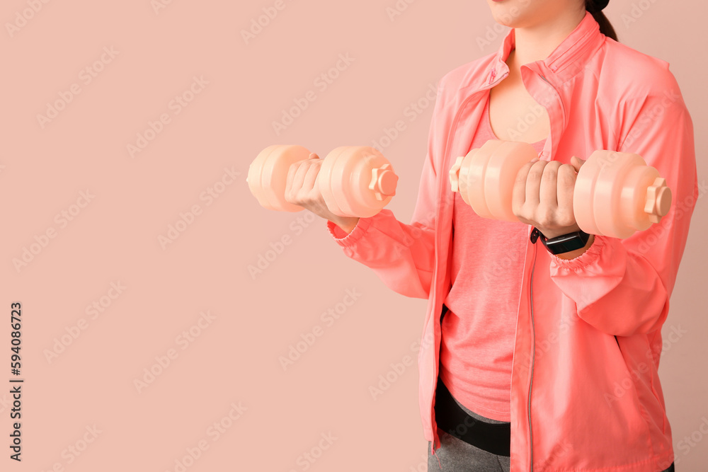 Sporty woman with dumbbells near pink wall, closeup