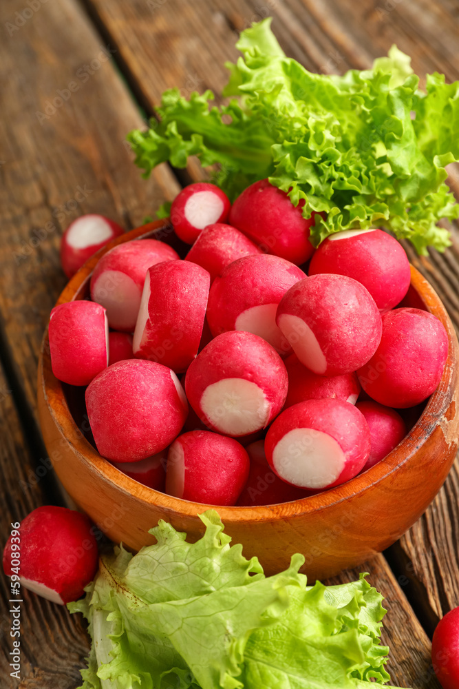 Bowl with fresh radish on wooden background