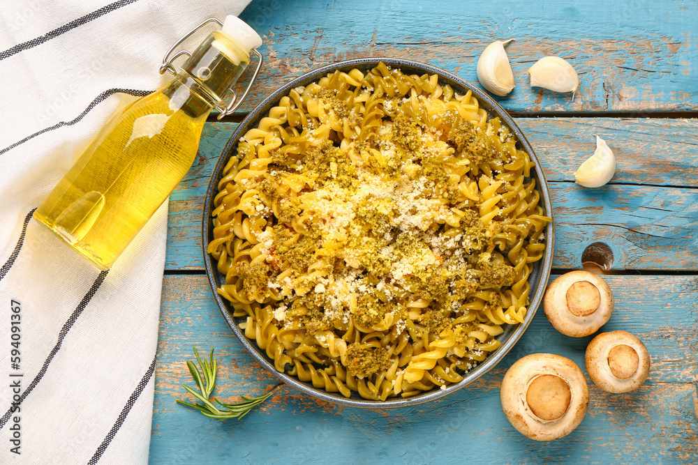 Plate of tasty Italian pasta with Parmesan cheese on blue wooden background