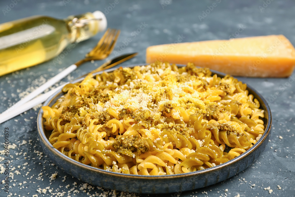 Plate of tasty Italian pasta with Parmesan cheese on blue background