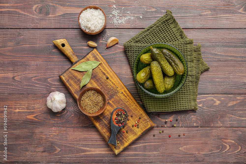 Bowl with tasty fermented cucumbers on wooden background