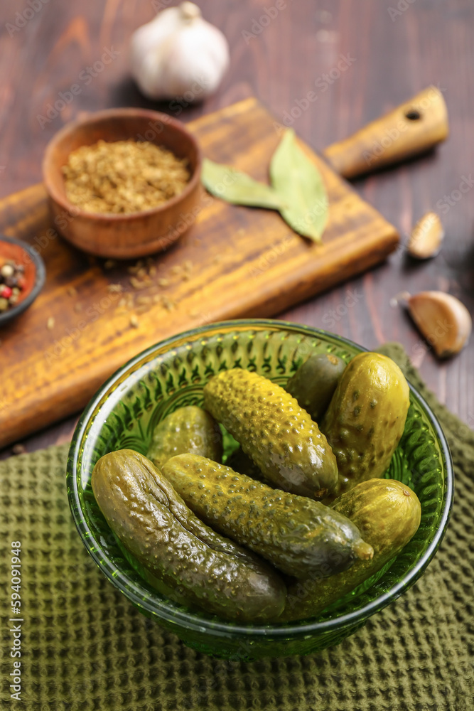 Bowl with tasty fermented cucumbers on wooden background