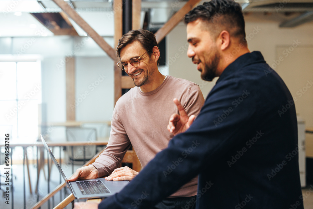 Business men video calling their clients on a laptop in an office