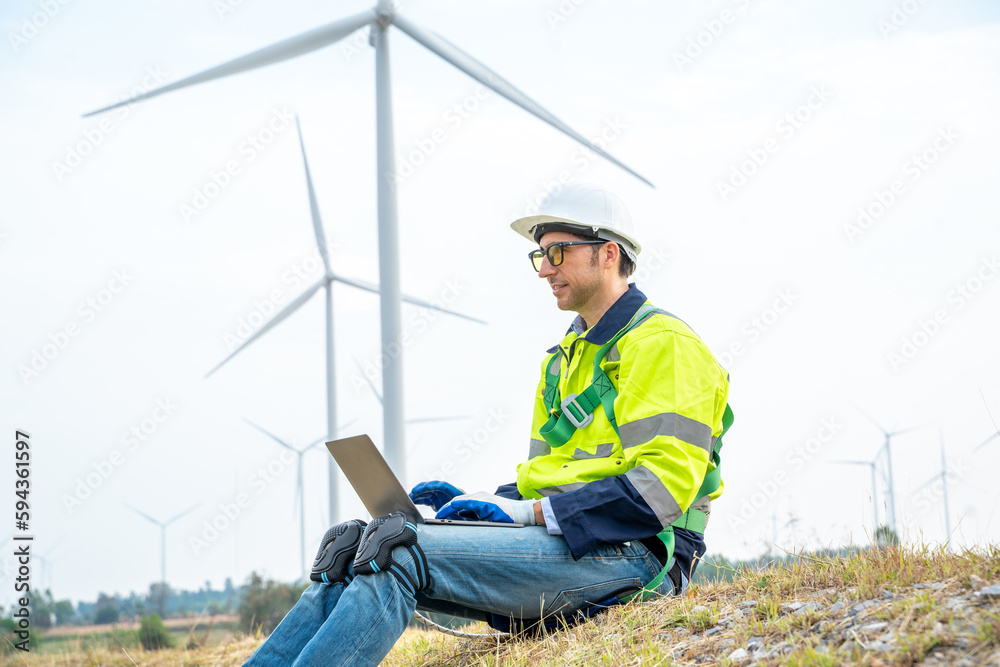 Engineer inspecting a wind turbine,Wind turbines are an alternative electricity source to be sustain