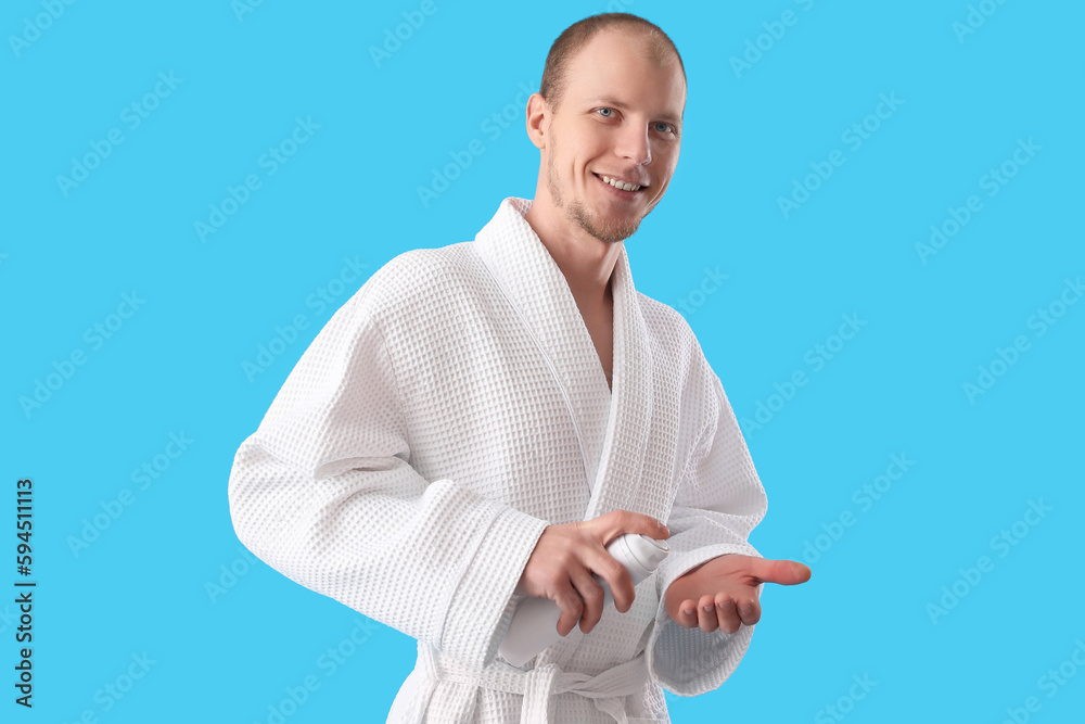 Young man with shaving foam on light blue background