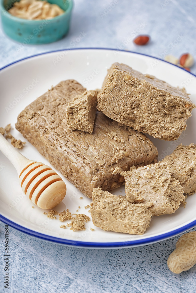 Plate of tasty halva on light background, closeup