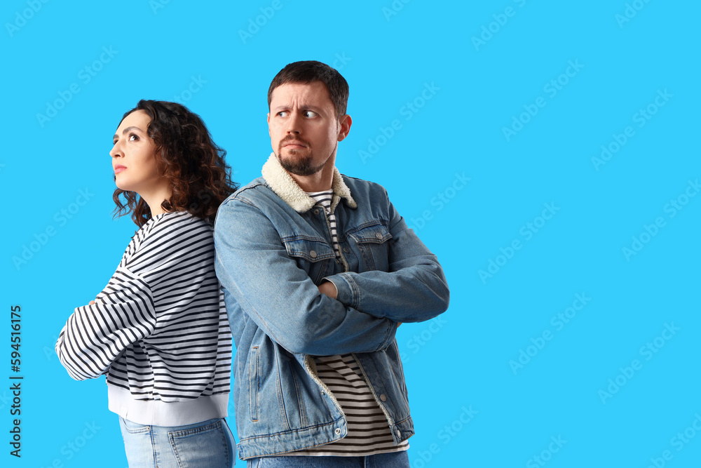 Upset young couple on blue background