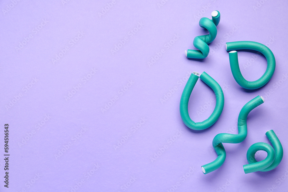 Hair curlers on lilac background