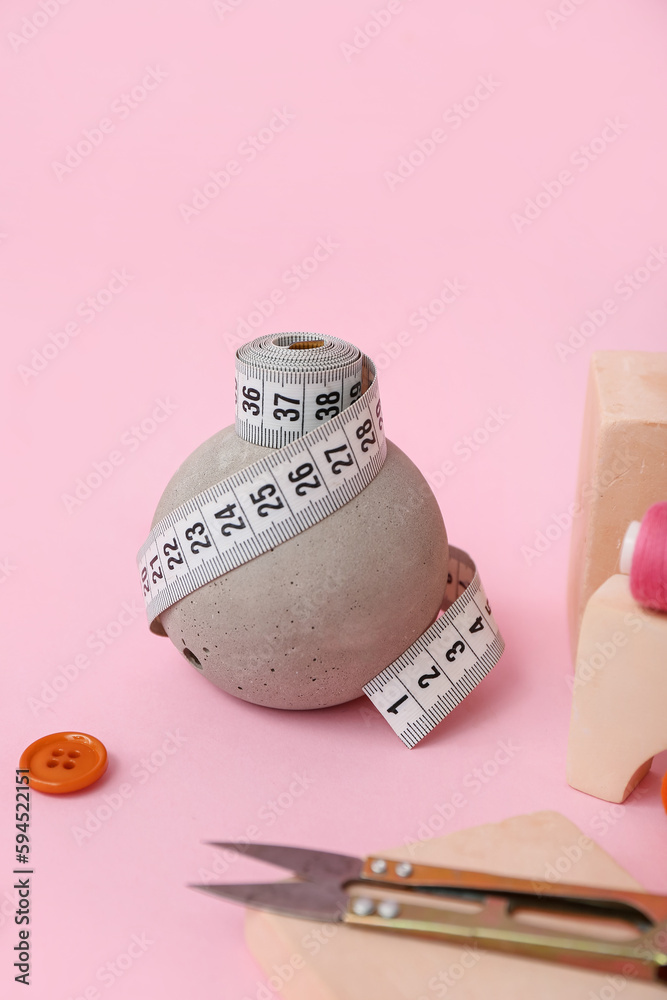 Podium with measuring tape on pink background, closeup