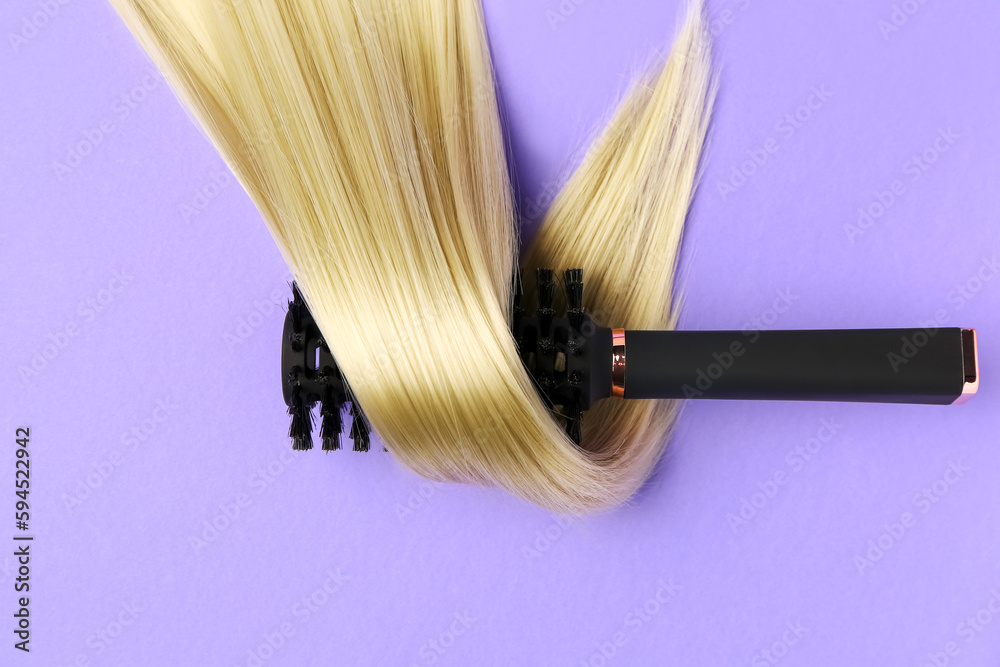 Hair strand with round brush on violet background