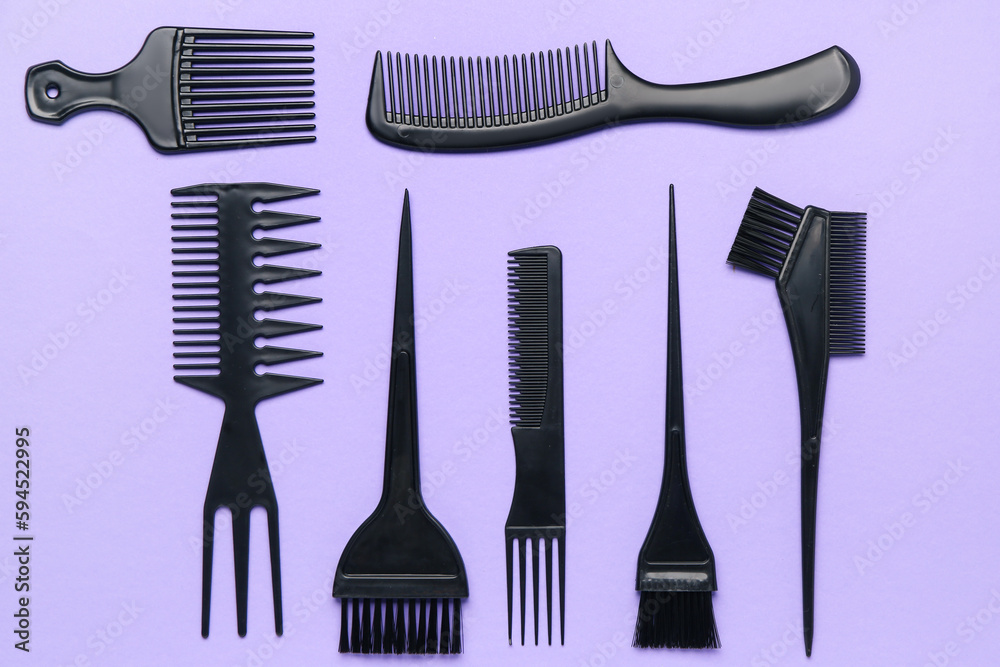 Hairdressers brushes on violet background