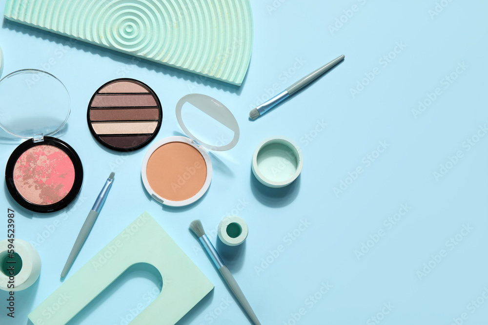 Decorative cosmetics with brushes and podiums on blue background