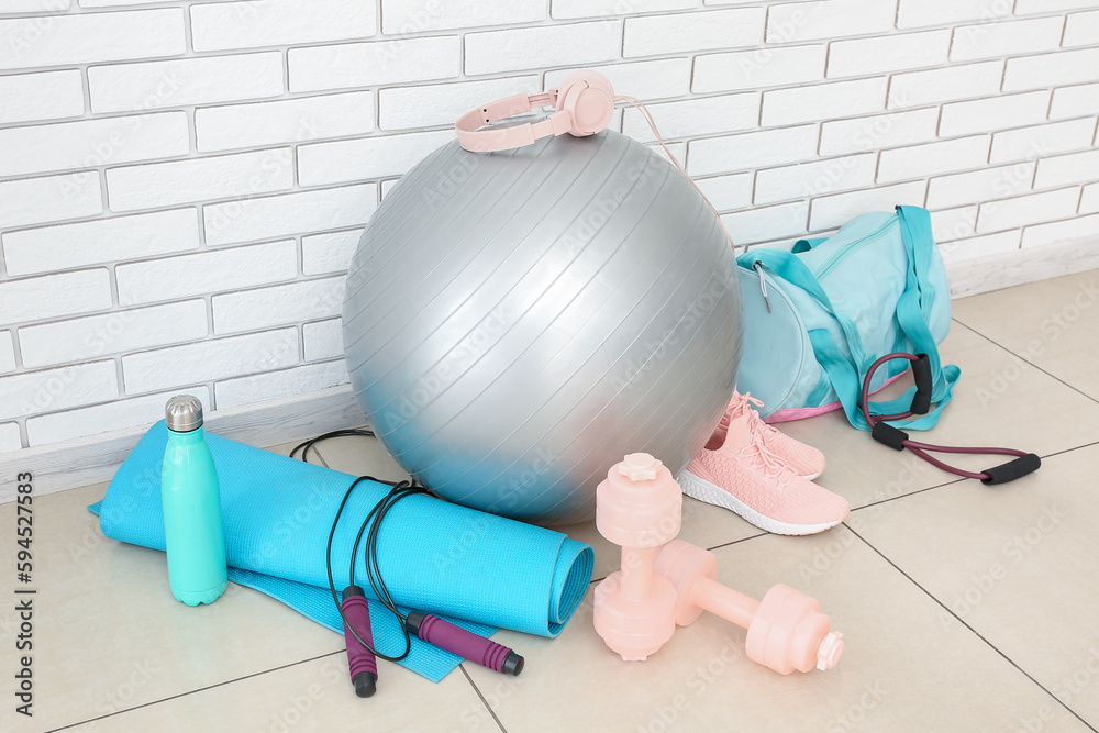 Sports equipment with bag near white brick wall