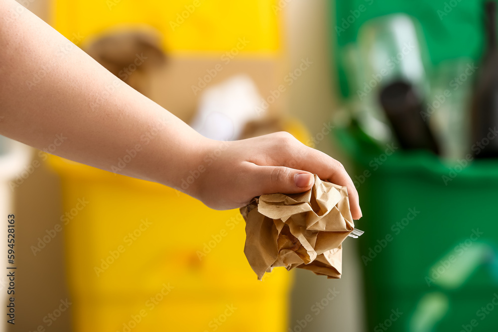 Woman throwing garbage into trash bin, closeup. Recycling concept