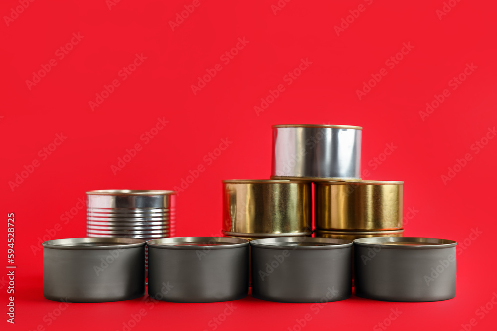 Assortment of tin cans with fish on red background