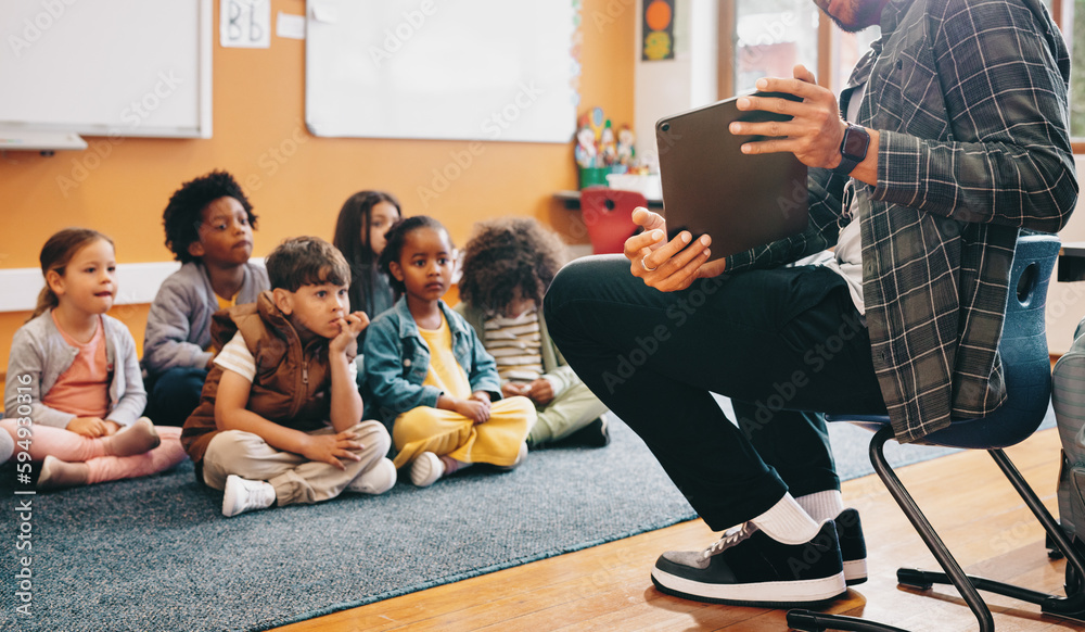 Primary school teacher using a tablet to give a lesson in class