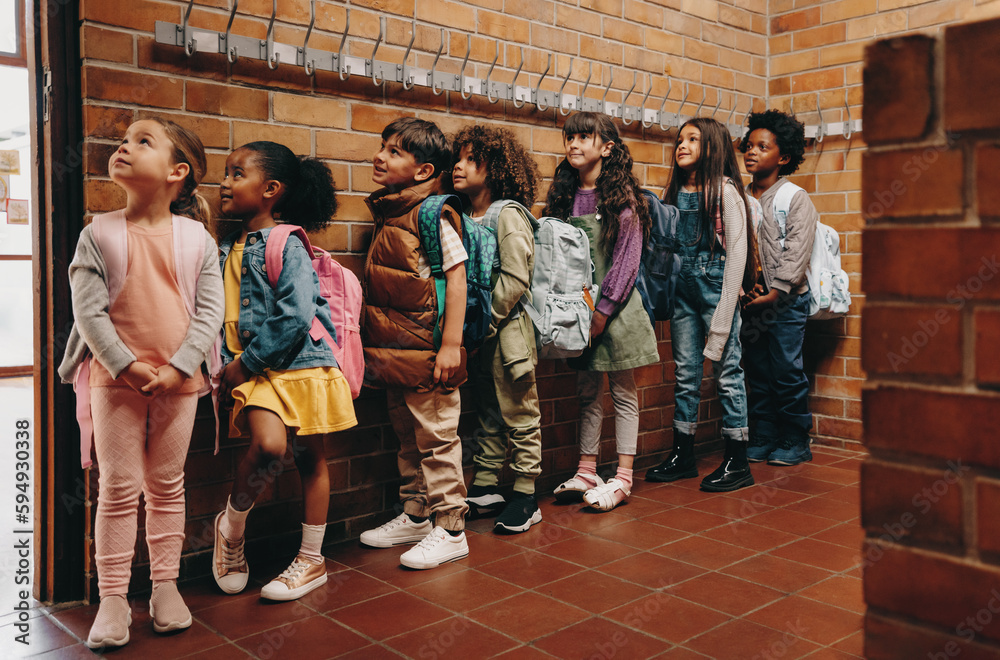 Primary school students waiting in line outside their classroom. Children waiting to start class in 