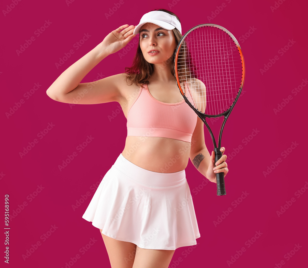 Young woman with tennis racket on pink background