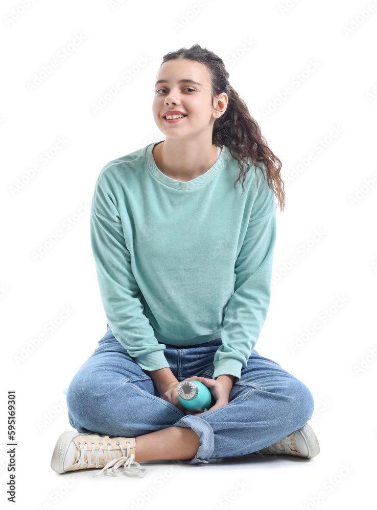 Teenage girl with bottle of water sitting on white background