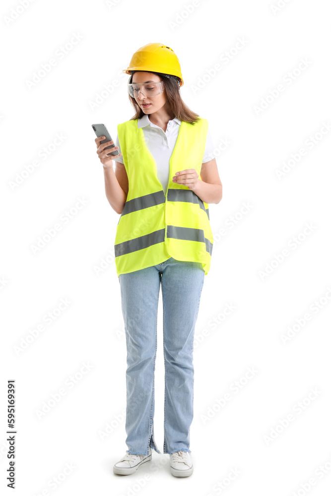 Female worker in vest and hardhat holding mobile phone on white background