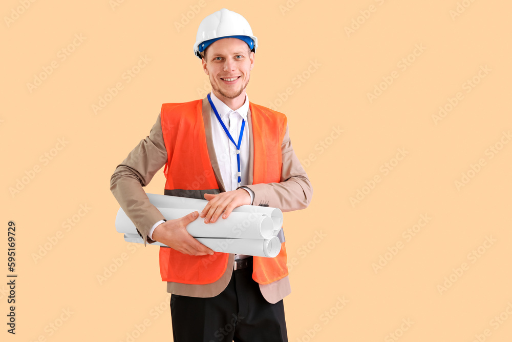 Male architect with drawing on beige background