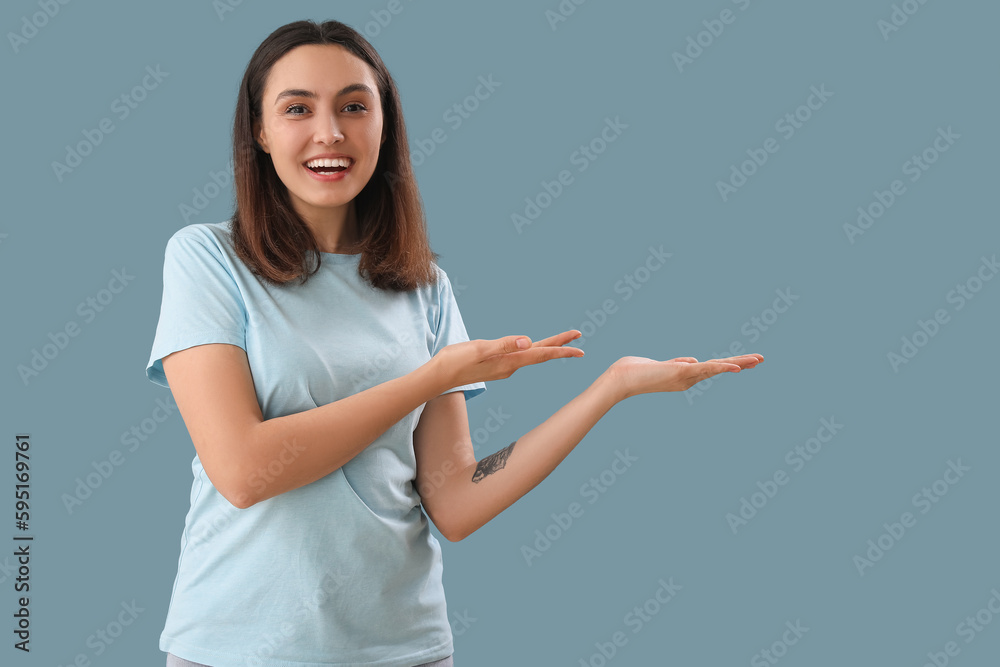 Young woman showing something on blue background