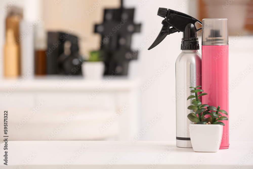 Different hair sprays on table in beauty salon