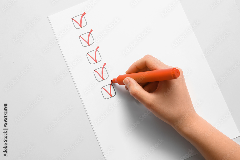 Woman marking on checklist box with orange marker