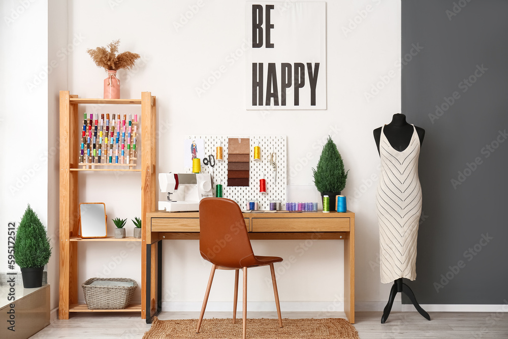 Interior of atelier with tailors workplace, pegboard and mannequin