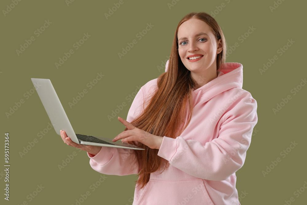 Female programmer working with laptop on green background