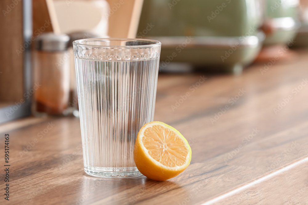 Glass of water and lemon on kitchen counter