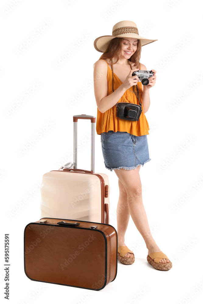 Female tourist with photo camera and suitcases on white background