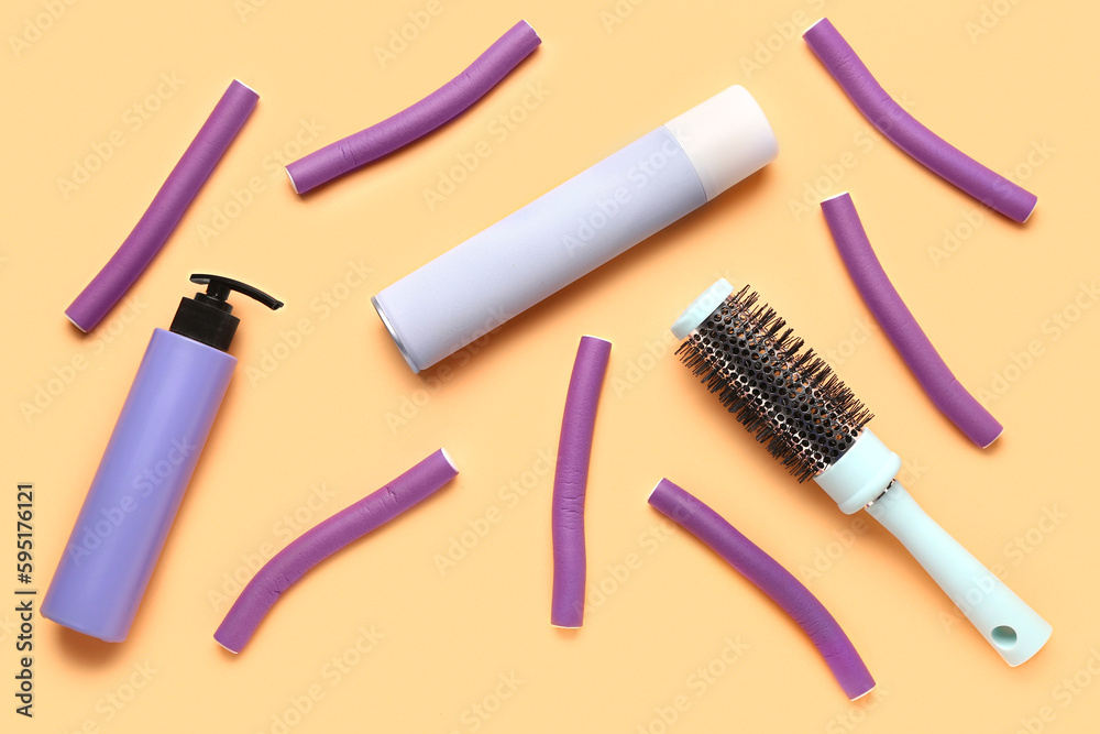 Hairdressers brush with sprays and curlers on color background