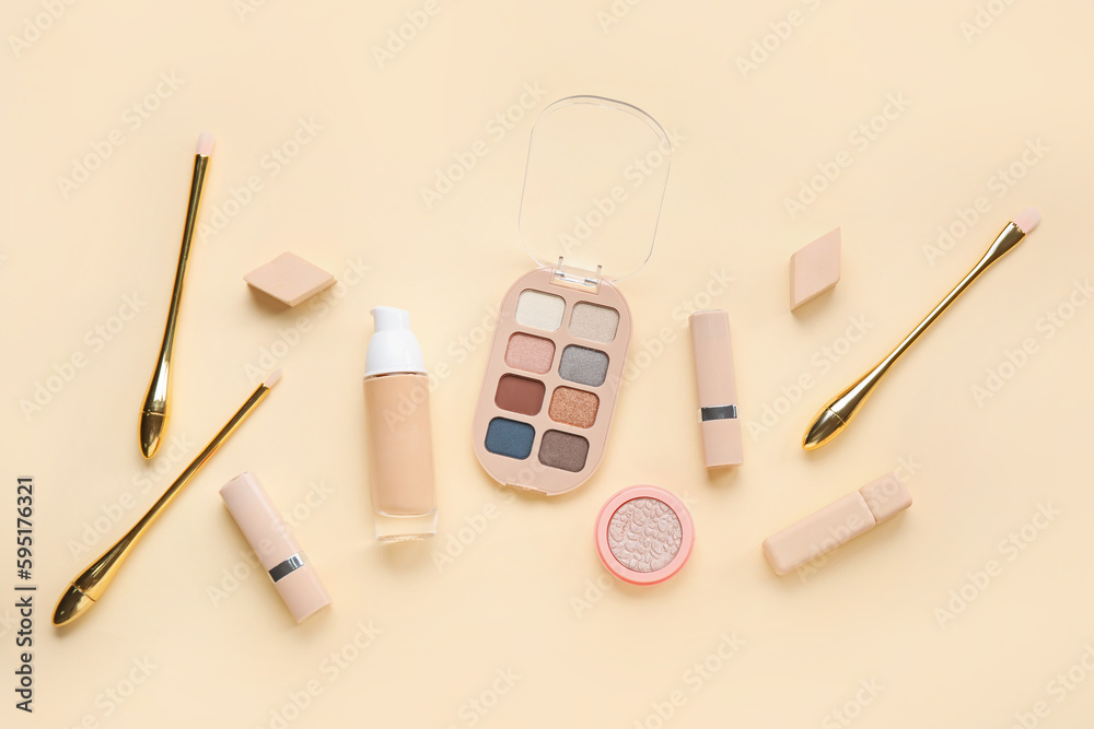 Decorative cosmetics with sponges and brushes on yellow background