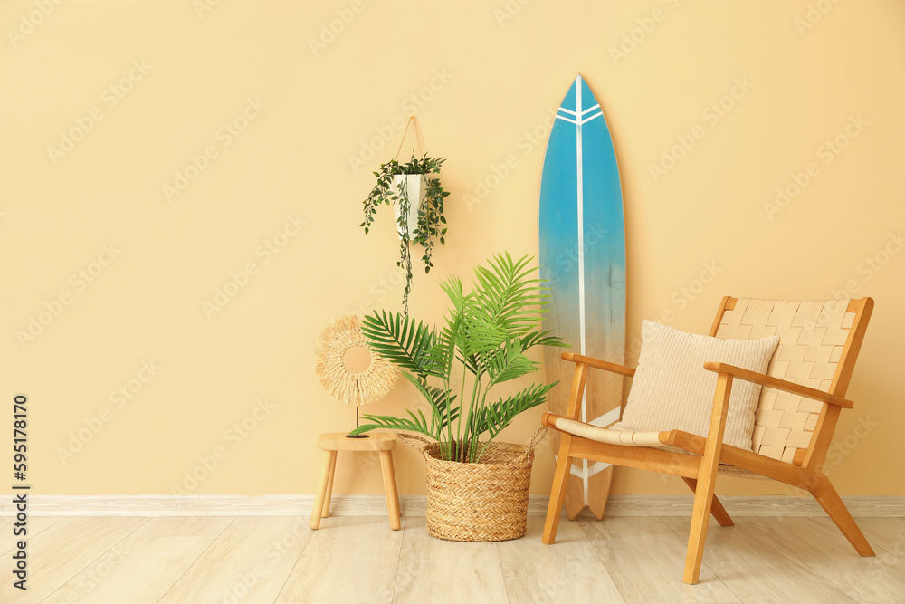 Interior of living room with surfboard, armchair and houseplants