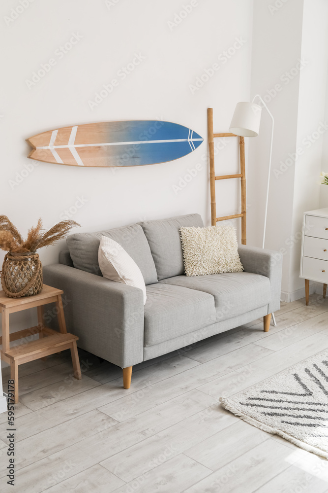 Interior of light room with surfboard and sofa