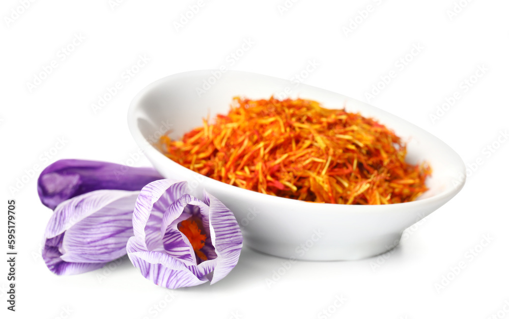 Bowl of dried saffron threads and crocus flowers isolated on white background