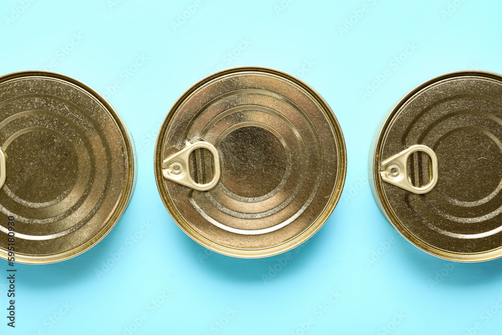 Tin cans with fish on blue background