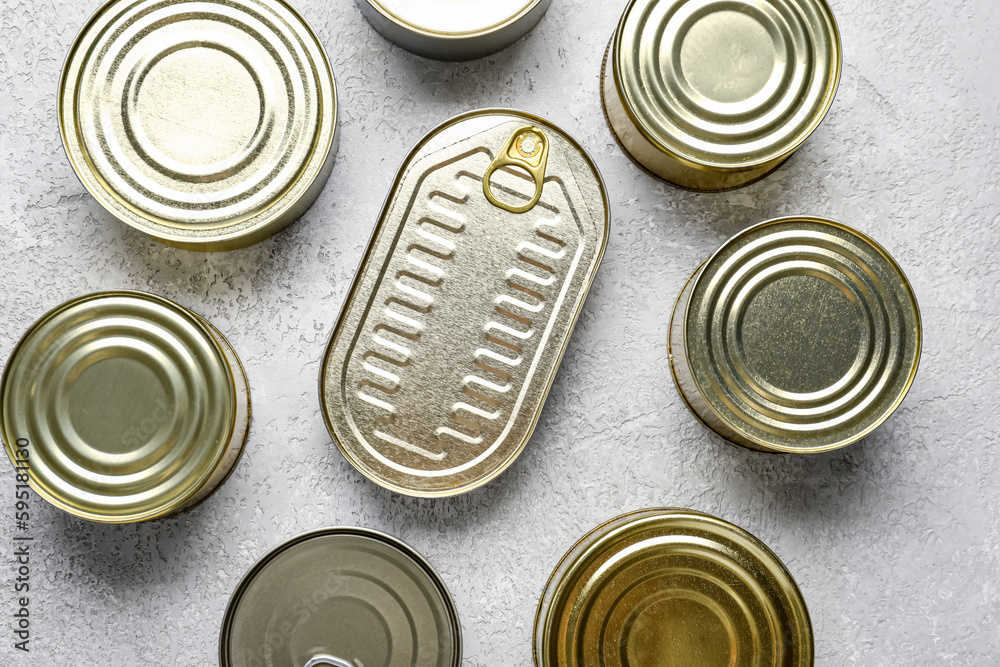 Assortment of tin cans with fish on grey table