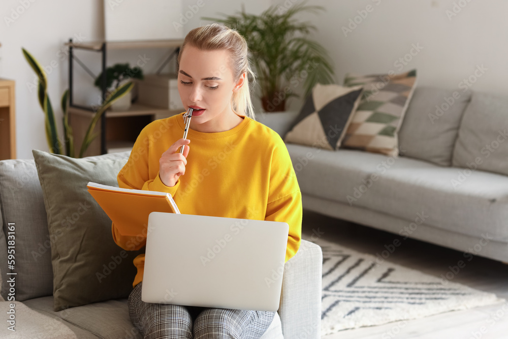 Female student studying online with notebook at home