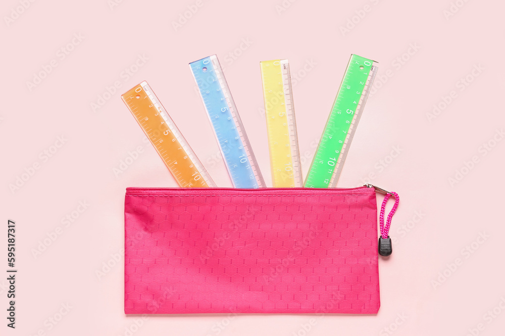 Colorful rulers on pink background