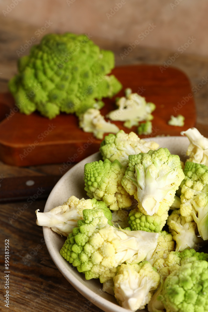 Bowl with baby romanesco cabbage on wooden table