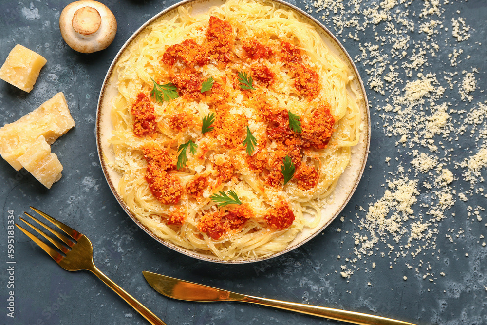 Plate of tasty Italian pasta with Parmesan cheese on blue background