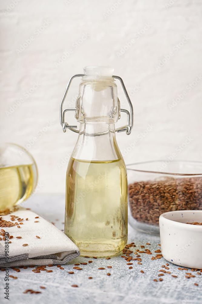 Bottle with flax oil and seeds on light table