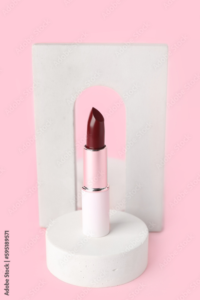 Decorative plaster podiums and lipstick on pink background